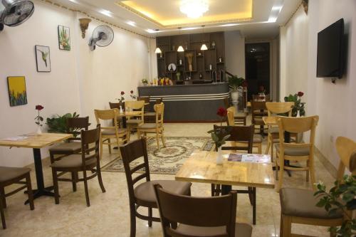 a restaurant with wooden tables and chairs and a counter at ChiChi Hotel Sapa in Sapa