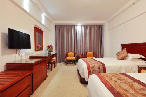 a hotel room with two beds and a flat screen tv at Sanyu Hotel in Guangzhou