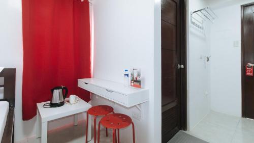 馬尼拉的住宿－RedDoorz near UST Sampaloc Manila，浴室设有2把凳子、水槽和红色窗帘