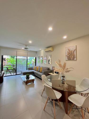 a living room with a table and chairs and a couch at Lujoso departamento en el corazón de Playa in Playa del Carmen