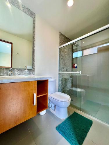 a bathroom with a toilet and a glass shower at Lujoso departamento en el corazón de Playa in Playa del Carmen