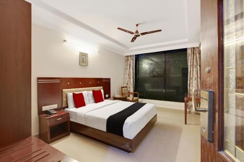 1 dormitorio con cama grande y ventana grande en Elegant Amethyst Business Hotel Near Ragigudda Sri Prasanna, en Bangalore