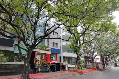una strada con alberi ed edifici su una strada di città di Elegant Amethyst Business Hotel Near Ragigudda Sri Prasanna a Bangalore