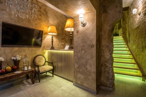 a hallway with a staircase with a chair and a television at Rooms by the sea Split - 18081 in Split