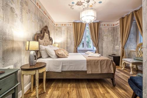 a bedroom with a bed and a table and a chandelier at Rooms by the sea Split - 18081 in Split