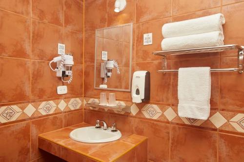 a bathroom with a sink and a mirror and towels at Casa Andina Standard Puno in Puno