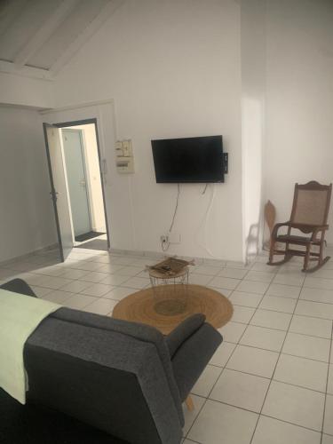 a bedroom with a bed and a tv on the wall at TRANSIT AFFAIRES - LOISIRS in Pointe-à-Pitre