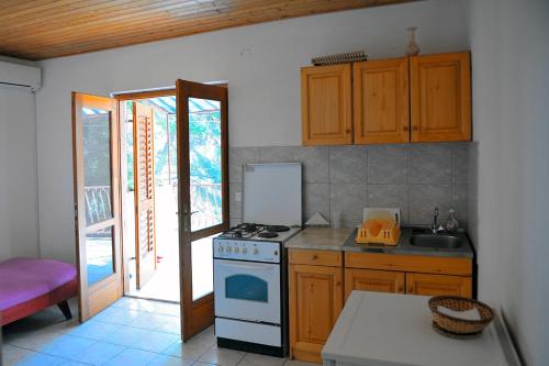 a kitchen with a stove and a sink at Apartments by the sea Ivan Dolac, Hvar - 18100 in Jelsa