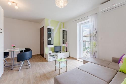 ein Wohnzimmer mit einem Sofa und einem Tisch in der Unterkunft Apartments with a parking space Solin, Split - 18064 in Solin
