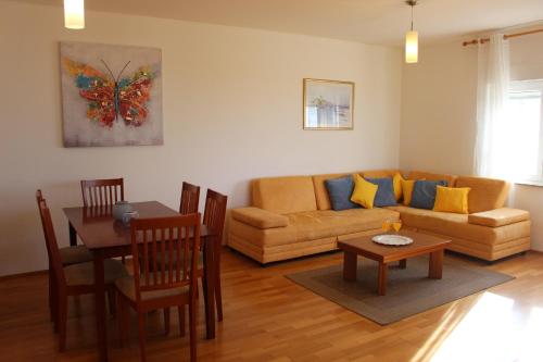 uma sala de estar com um sofá e uma mesa em Family friendly apartments with a swimming pool Kozino, Zadar - 18128 em Kožino
