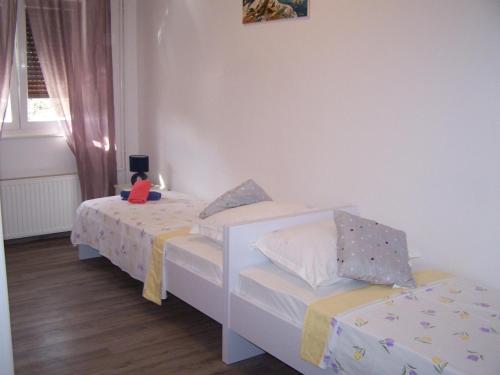 a bedroom with two beds and a table with a laptop on it at Apartments by the sea Novalja, Pag - 18154 in Novalja