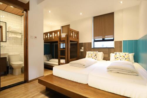 a bedroom with two beds and a bathroom at Lychee Sunset Hotel Cheung Chau in Hong Kong