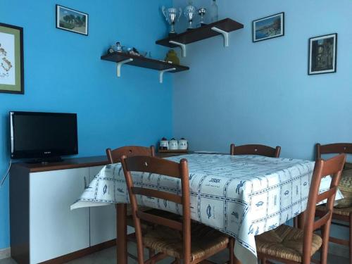 a dining room with a table and a blue wall at villa Fiore in Borgo Diano San Pietro in Diano San Pietro
