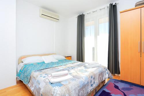 een slaapkamer met een bed met twee handdoeken erop bij Apartments with a parking space Makarska - 18145 in Makarska