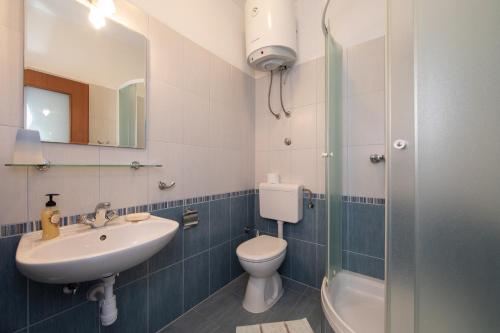 a bathroom with a sink and a toilet and a shower at Apartments by the sea Igrane, Makarska - 18069 in Igrane