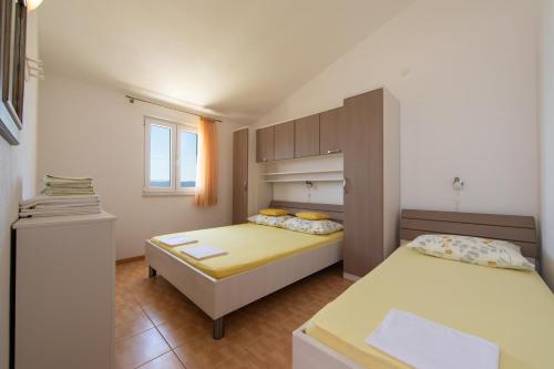 a small bedroom with two beds and a window at Apartments by the sea Igrane, Makarska - 18069 in Igrane