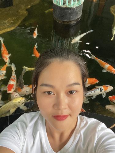 a young woman in front of a pond of koi at V A C Haven Viet Nam 2 in Phú Mỹ