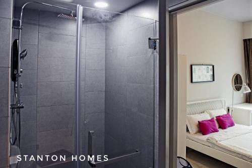 a glass shower door in a bedroom with a bed at Jesselton Quay HOMESTAY by Stanton Homes in Kota Kinabalu