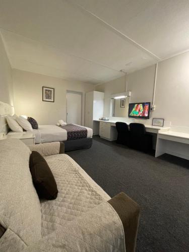 a hotel room with two beds and a flat screen tv at Parkside Inn Motel in Melbourne