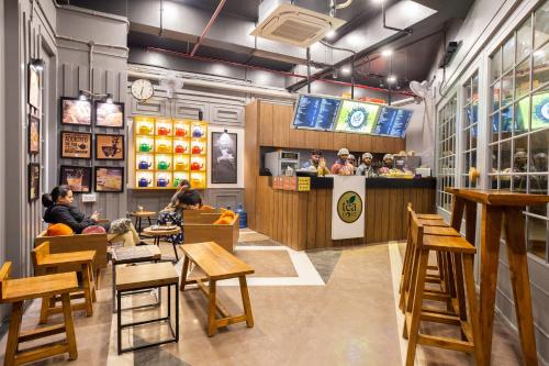 a restaurant with people sitting at tables and a counter at OYO Hotel Honey House in Mahabaleshwar