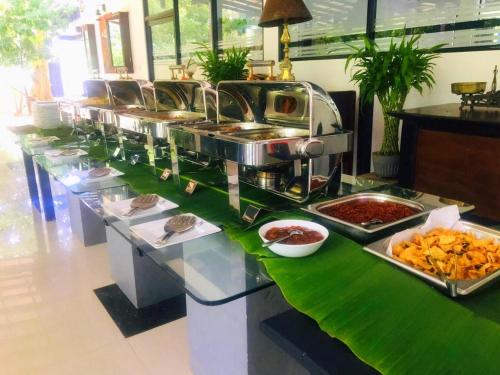 a buffet line with dishes of food on a table at Flower Garden Eco Village in Sigiriya