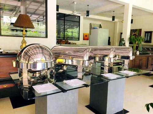 a glass table with a couch in a room at Flower Garden Eco Village in Sigiriya