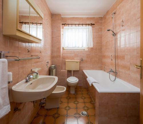 a bathroom with a sink and a tub and a toilet at Apartments and rooms by the sea Duce, Omis - 18155 in Omiš