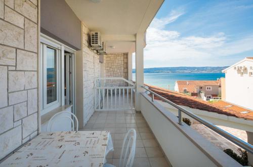 a balcony with a table and a view of the ocean at Apartments and rooms by the sea Duce, Omis - 18155 in Omiš