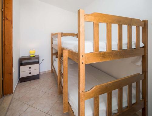 two bunk beds in a room with a night stand at Apartments and rooms by the sea Duce, Omis - 18155 in Omiš
