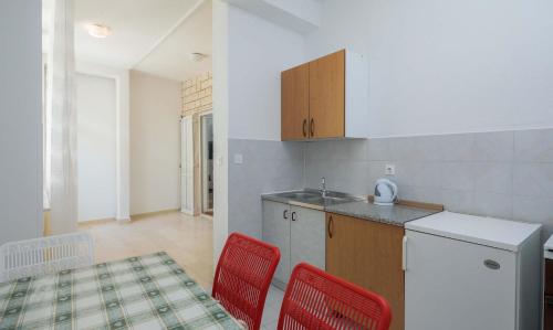 a kitchen with two red chairs and a counter at Apartments and rooms by the sea Duce, Omis - 18155 in Omiš