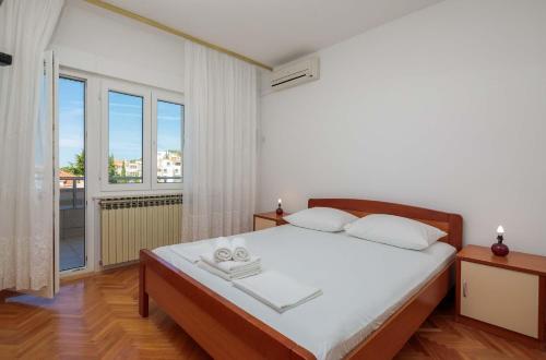 - une chambre avec un lit et une grande fenêtre dans l'établissement Apartments and rooms by the sea Duce, Omis - 18155, à Omiš