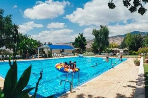 - une grande piscine avec des personnes sur un radeau dans l'établissement סוויטת מול הבניאס, à Kibbutz Snir