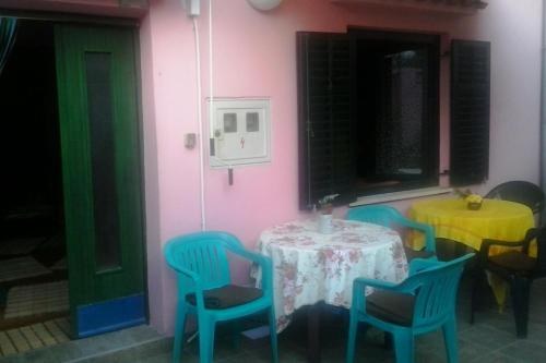 a table and chairs in a room with a pink wall at Rooms with WiFi Susak, Losinj - 18208 in Susak