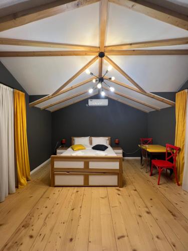 a bedroom with a bed and a table in a room at Borjomi Yellow Hotel in Borjomi