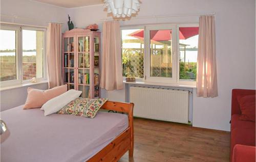 a bedroom with a bed and windows and a couch at Beautiful Home In Mscice With 4 Bedrooms And Wifi in Mścice