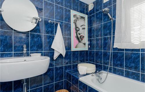 baño de azulejos azules con lavabo y aseo en Cozy Home In Mscice With House Sea View, en Mścice
