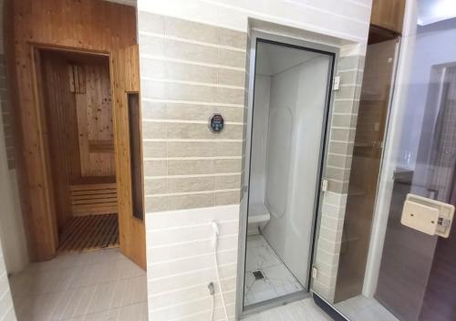 a walk in shower with a glass door in a bathroom at Khai Hoan Apartment Hotel in Ho Chi Minh City