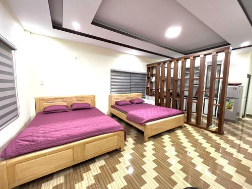 2 Betten mit lila Bettwäsche in einem Zimmer in der Unterkunft BobbyFarm in Buôn Buk So (1)