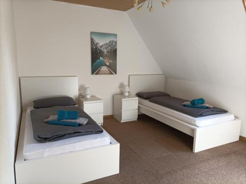 two beds in a room with white walls at BmB Kirchwalsede Monteurzimmer / Unterkunft in Kirchwalsede