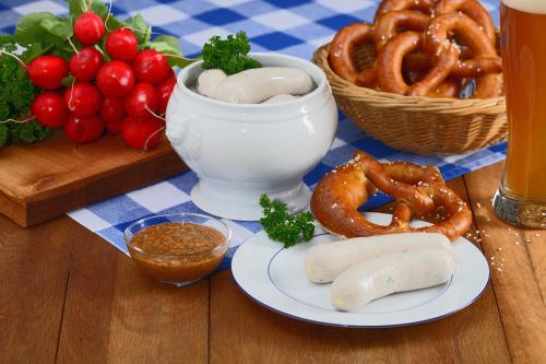 una mesa con un plato de pretzels y un tazón de aros de cebolla en Senefelder Hof, en Solnhofen