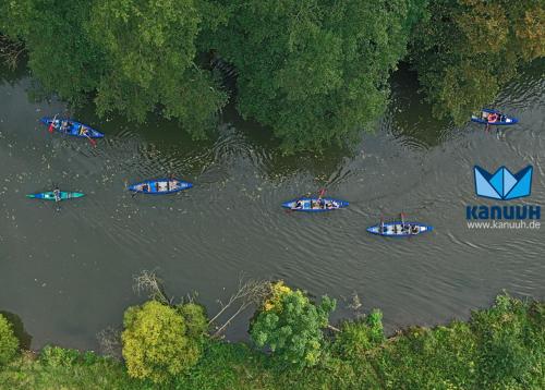 un grupo de barcos en un río con árboles en Senefelder Hof, en Solnhofen