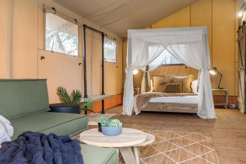 a bedroom with a bed with a canopy at Ballina Beach Nature Resort in Ballina