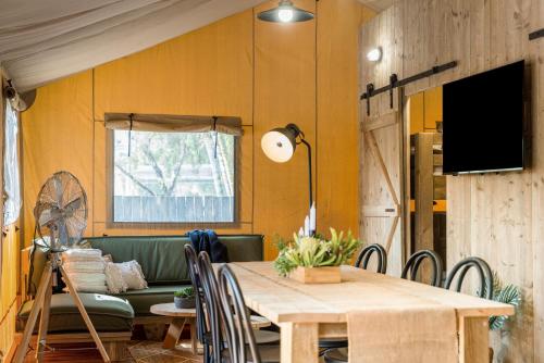 a dining room with a table and a couch at Ballina Beach Nature Resort in Ballina