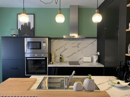 a kitchen with a sink and a stove top oven at Chez Paul et Louis in Rodez