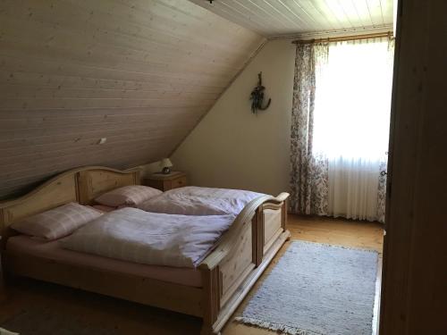 a bedroom with a bed in a attic with a window at Haeberlhaus in Königstein in der Oberpfalz