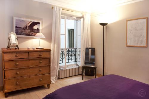 - une chambre avec une commode et un balcon dans l'établissement Chic Saint Germain Apartment, à Paris