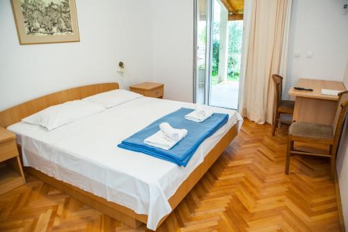 a bedroom with a bed with towels on it at Apartments and rooms with a swimming pool Lokva Rogoznica, Omis - 18328 in Lokva Rogoznica