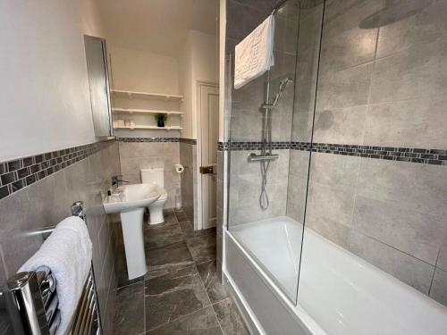 a bathroom with a shower and a tub and a sink at URBAN CITY SUITES 4 bed house, garden, Ideal for Contractors&Families in Quinton