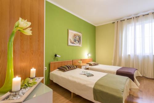 una stanza con due letti e un vaso con un fiore di Apartments with a parking space Fazana - 18334 a Fažana
