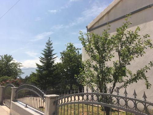 a fence with a tree next to a building at Apartments with parking space Katuni, Zagora - 18344 in Šestanovac